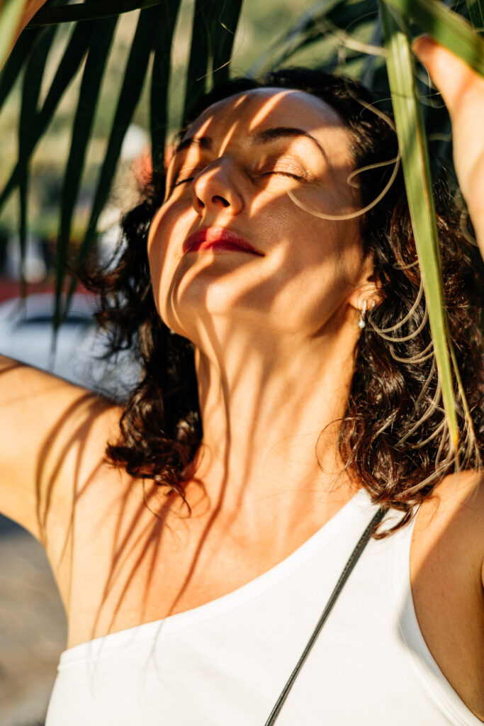 Femme ressentant une joie calme et corporelle dans une lumière chaude